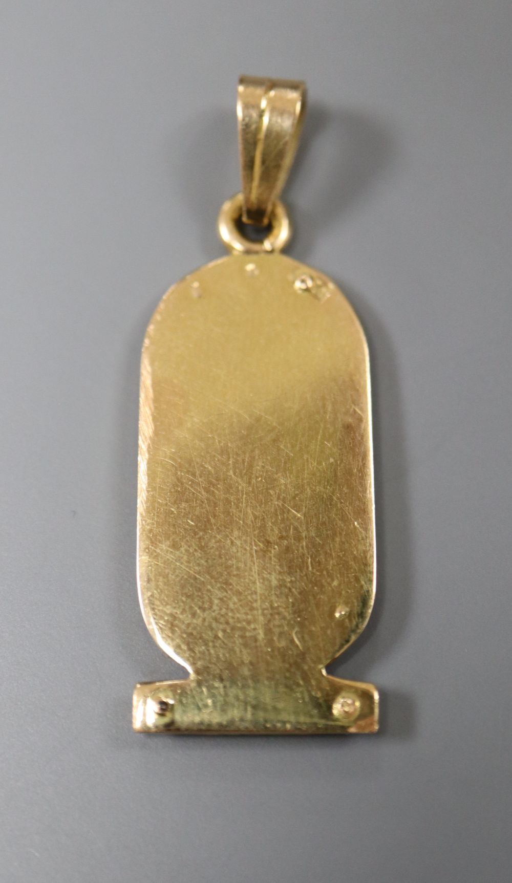 An Egyptian yellow metal and diamond set hieroglyphics pendant, 27mm, gross 4.3 grams.